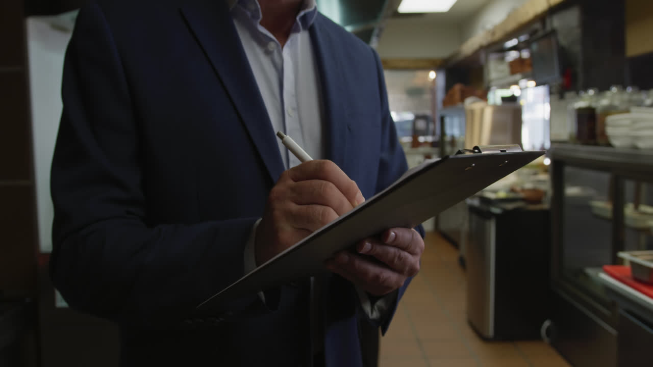Caucasian man writing in the kitchen