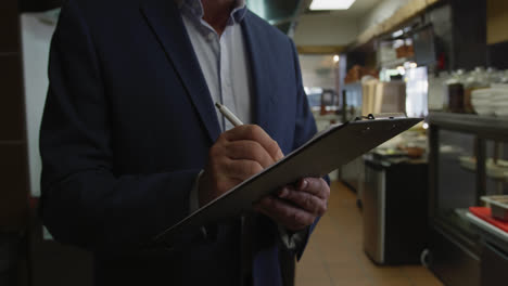 Caucasian-man-writing-in-the-kitchen