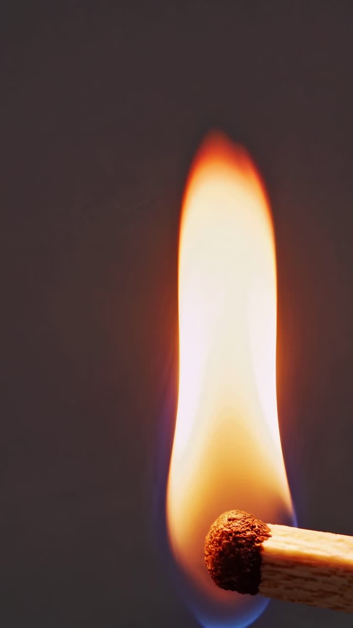 Close-up video of a matchstick igniting, captured from a side angle
