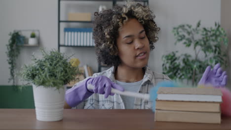 woman cleaning books and plants