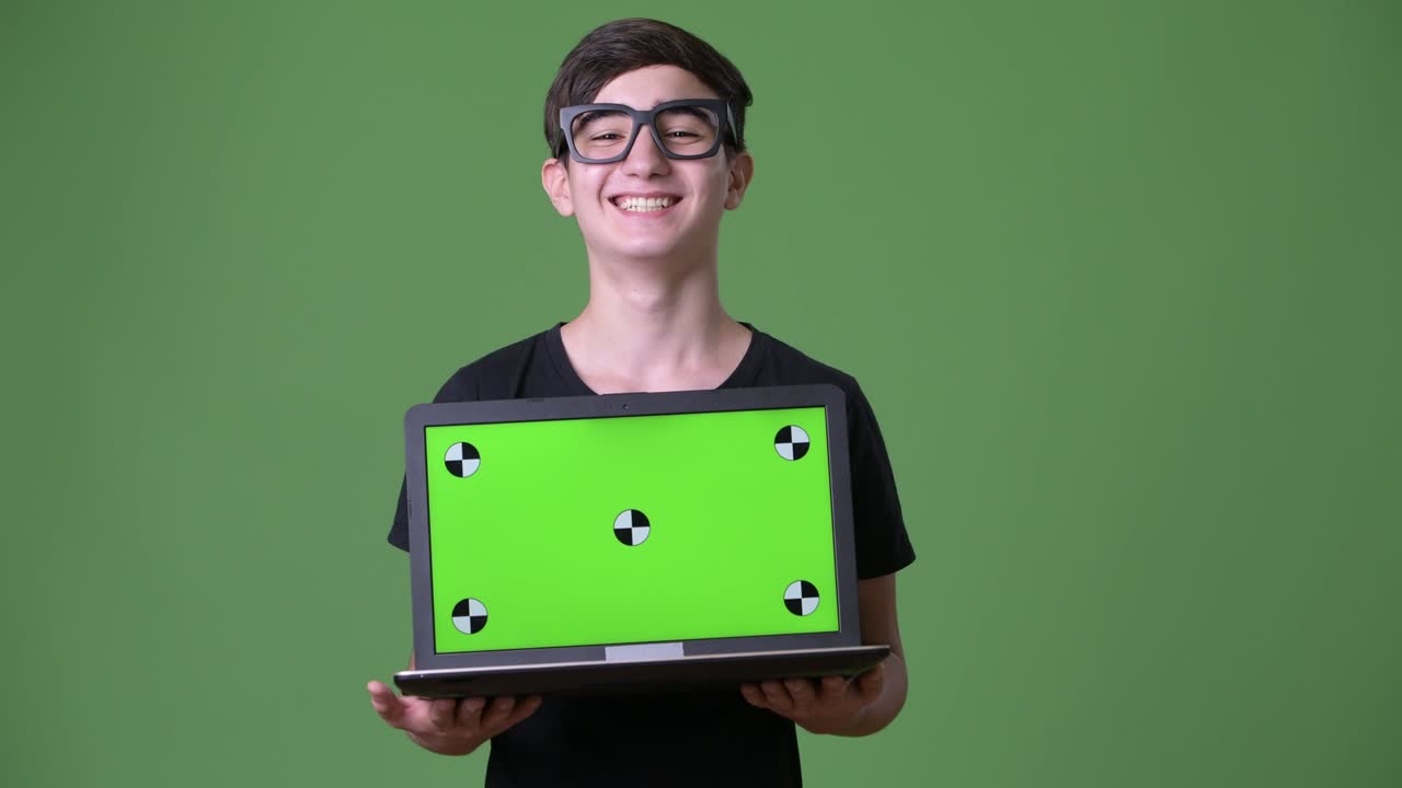 joven y guapo adolescente iraní contra un fondo verde