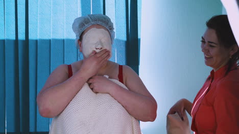 woman with overweight and alginate mask and cosmetologist