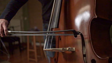 footage of a musician playng a double bass with a bow closeup