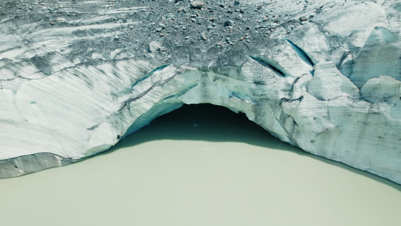 cueva de hielo gigante en un glaciar que se derrite en un lago debajo debido al cambio climático en los alpes, vista desde arriba