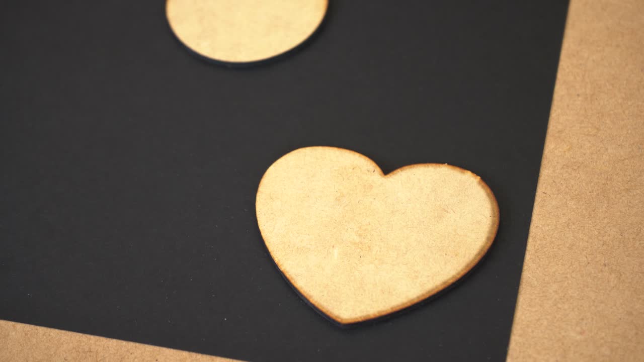 Heart-shaped MDF piece on black surface, focus on craftsmanship