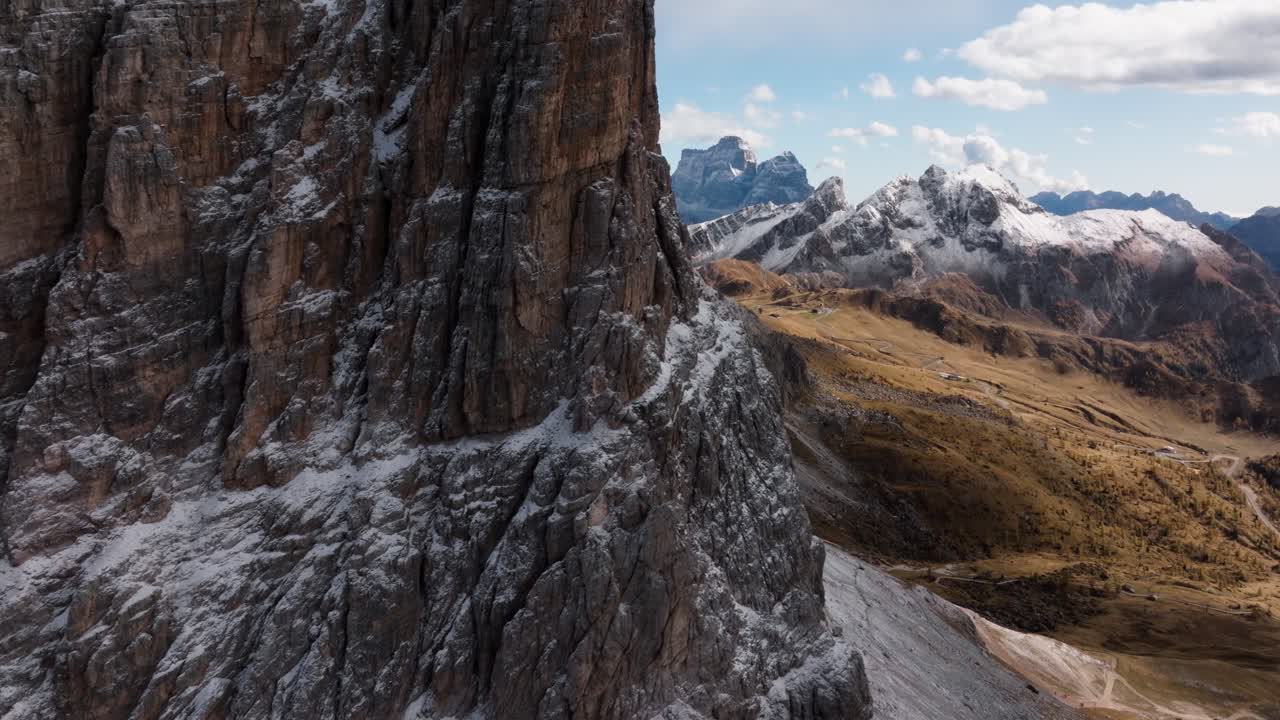 The drone goes behind a mountain after showing the colourful valley near Pass Falzarego