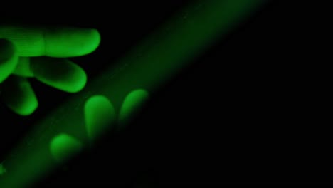 mano tocando una pantalla de teléfono por la noche en la luz verde