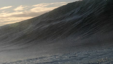 una ola corta y pesada rompe sobre una cornisa de roca poco profunda mientras el sol sale en el fondo de la costa este de australia