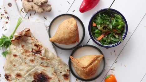 Comida-India-Tradicional-Snack-Samosa-Servido-En-Un-Plato-Sobre-Una-Mesa-De-Madera-Blanca