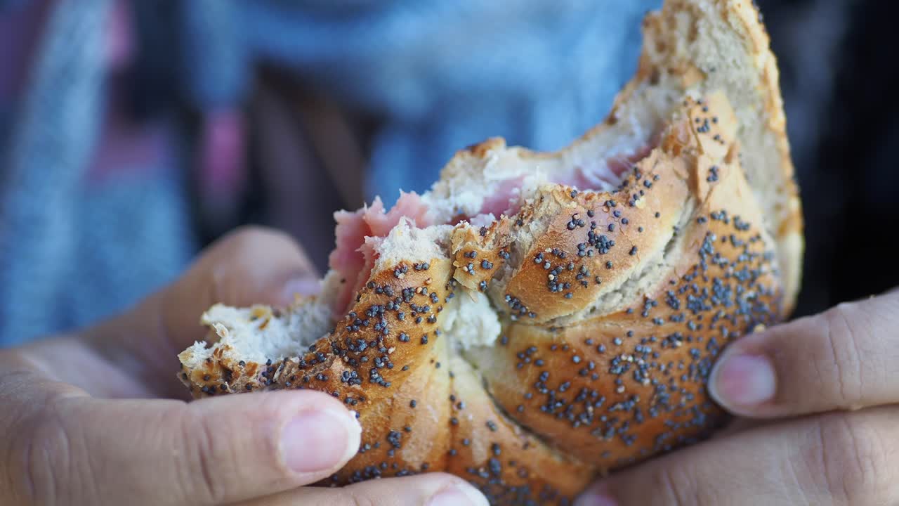 primer plano de un sándwich de bagel en la mano