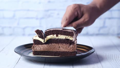 person eating a slice of chocolate cake