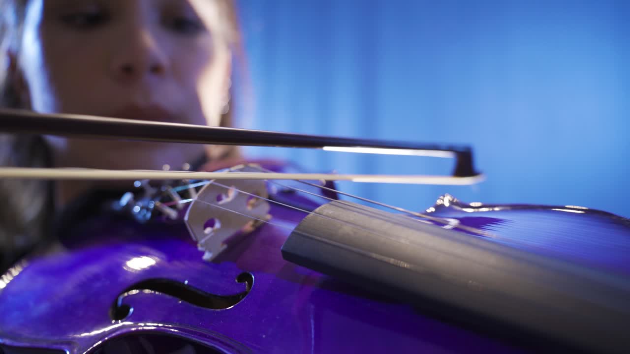 primer plano de un músico tocando el violín en el escenario.