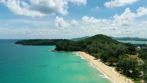 4k cinematic nature aerial footage of a drone flying over the beautiful beach of surin in phuket, thailand on a sunny day