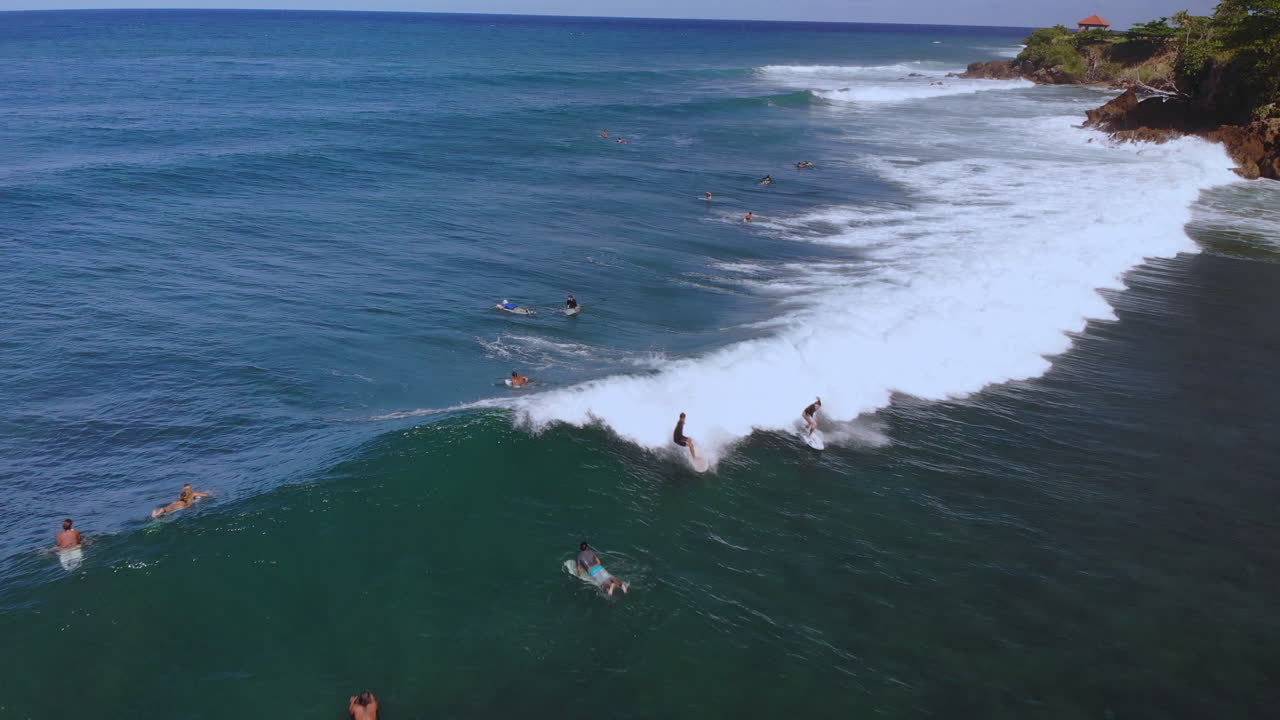 surfista montando una ola rompiendo mientras está en el océano en rincón puerto rico durante un día claro con cielo azul