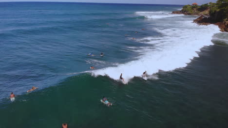 Surfer-riding-a-breaking-wave-while-in-the-ocean-in-Rincon-Puerto-Rico-during-a-clear-day-with-blue-sky