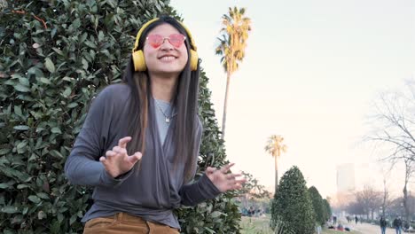 woman with headphones and sunglasses in a park