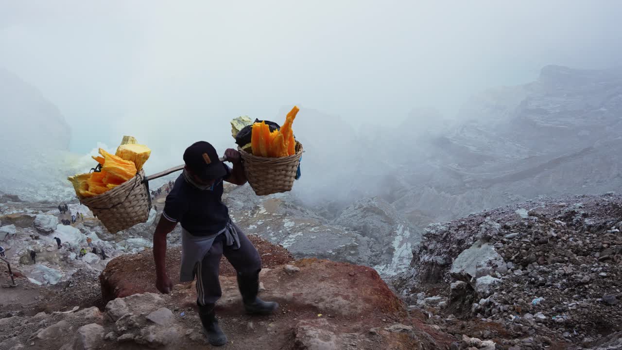 Endonezya'nın Doğu Cava Bölgesindeki Kawah Ijen Volkan Kraterinden Gündüz Vakti Aşırı Ağır Kükürt Yükü Taşıyan Madenci, Geniş Çekim