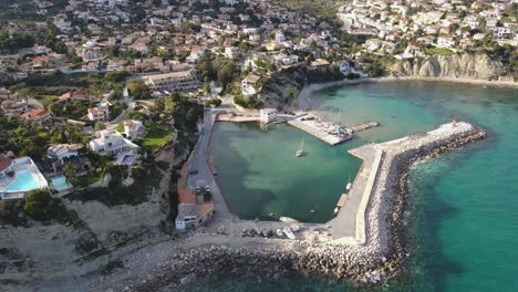 a coastal town with harbor, boats, and clear turquoise water in calpe, spain, aerial view