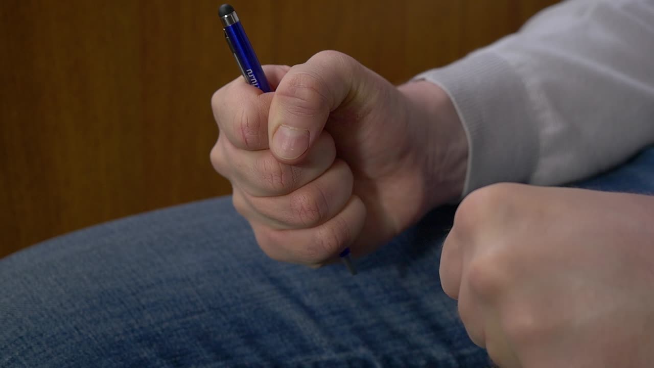 persona que sostiene un bolígrafo