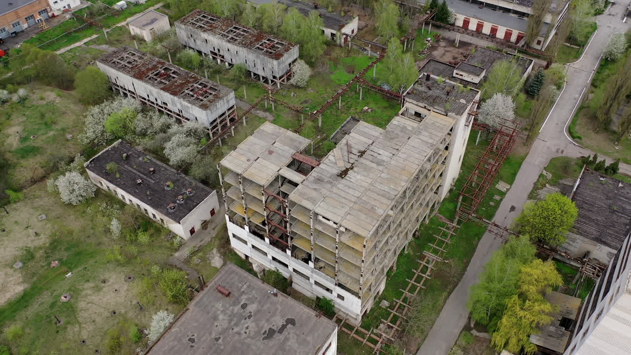 Ruined factory buildings. Abandoned warehouses or production department on the factory territory. Old industrial edifices for demolition. Aerial view.