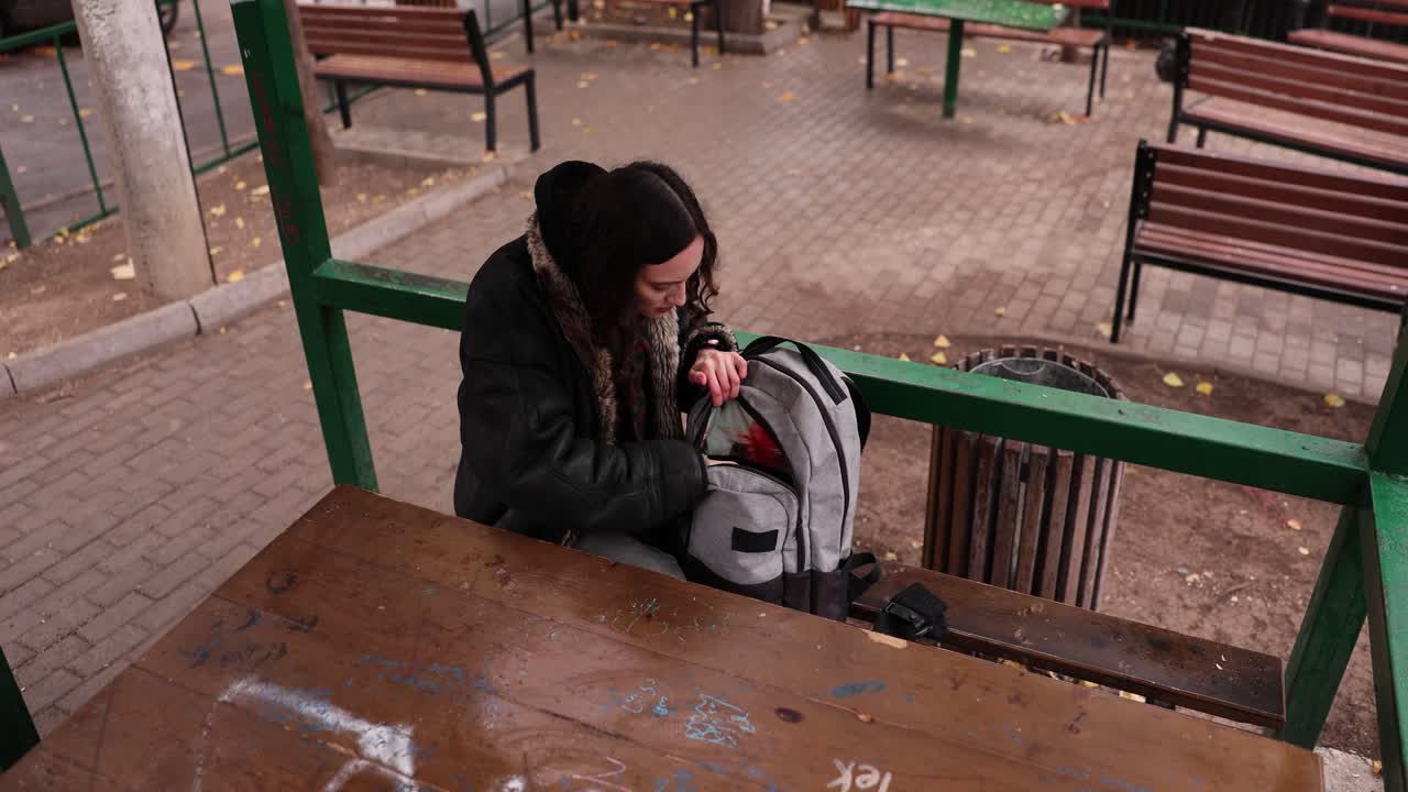 Woman with a backpack at an outdoor table