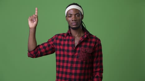 young handsome african man with dreadlocks against green background