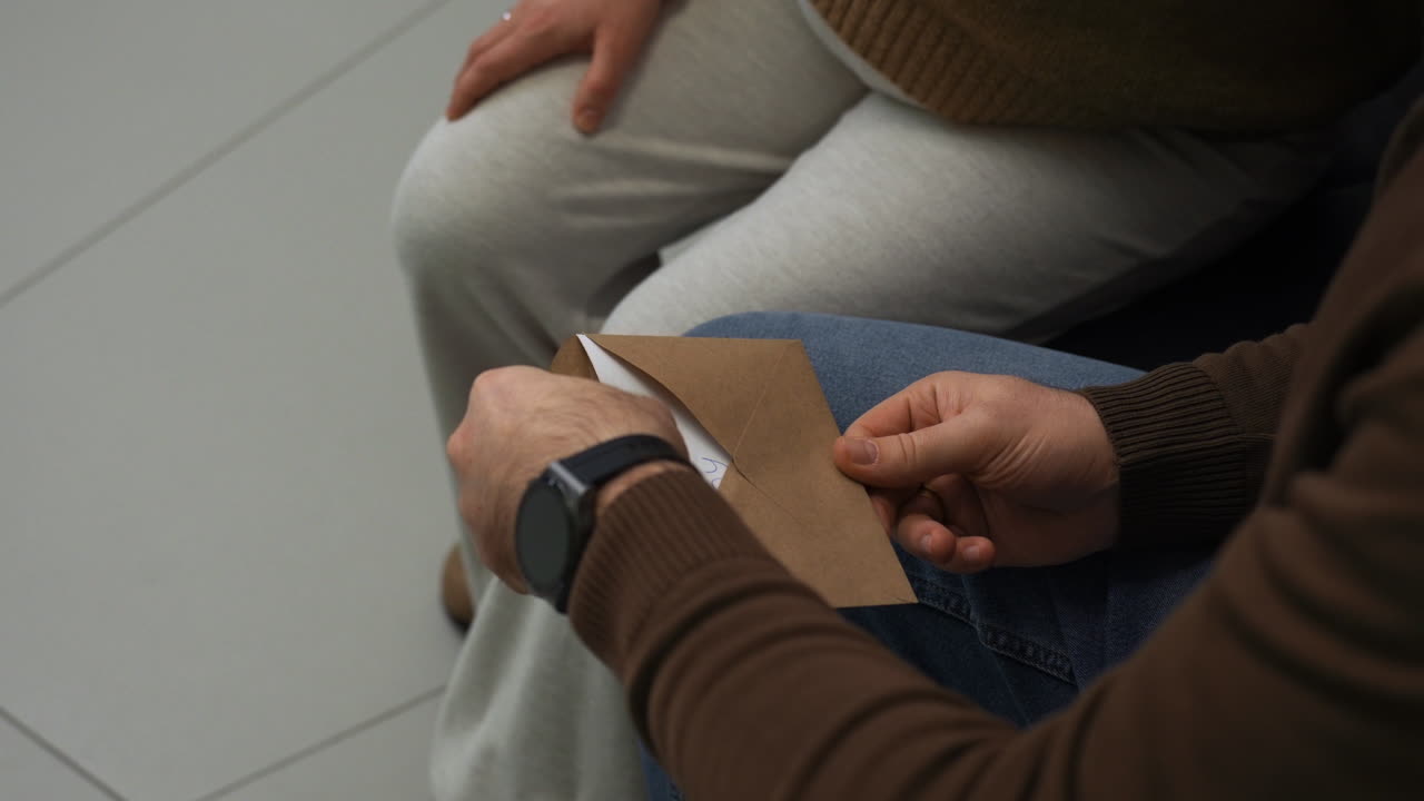 남자 가 종이 에 쓰여진 소년 과 함께 봉투 를 열고