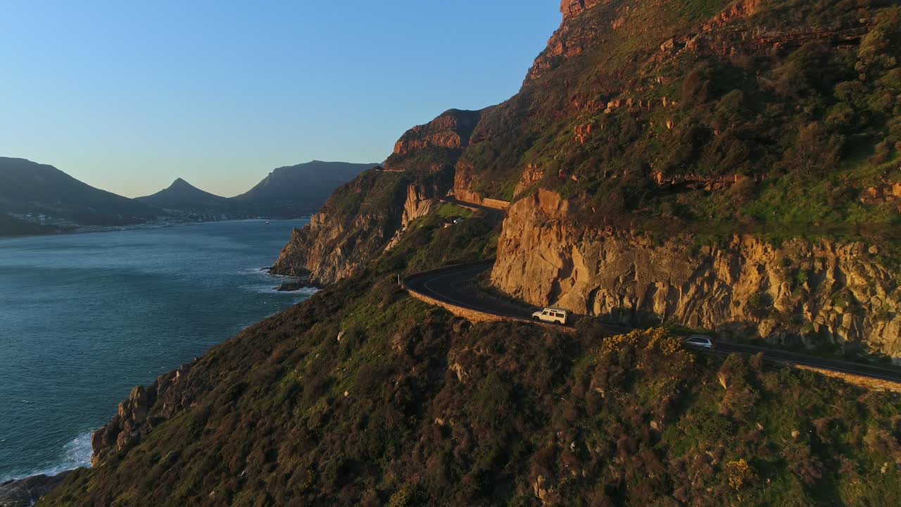 해안 산길을 따라 이동하는 자동차의 공중 촬영