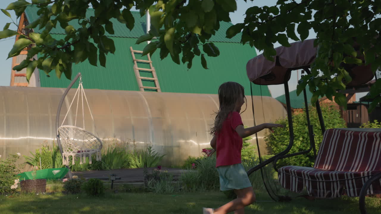 Young Girl Plays Freely With Her Dog Outside, Family Spends Warm Summer Day Playing With Their Pet Outdoors, Young Girl Runs Happily With Her Dog Beside Rustic House On Sunny Afternoon