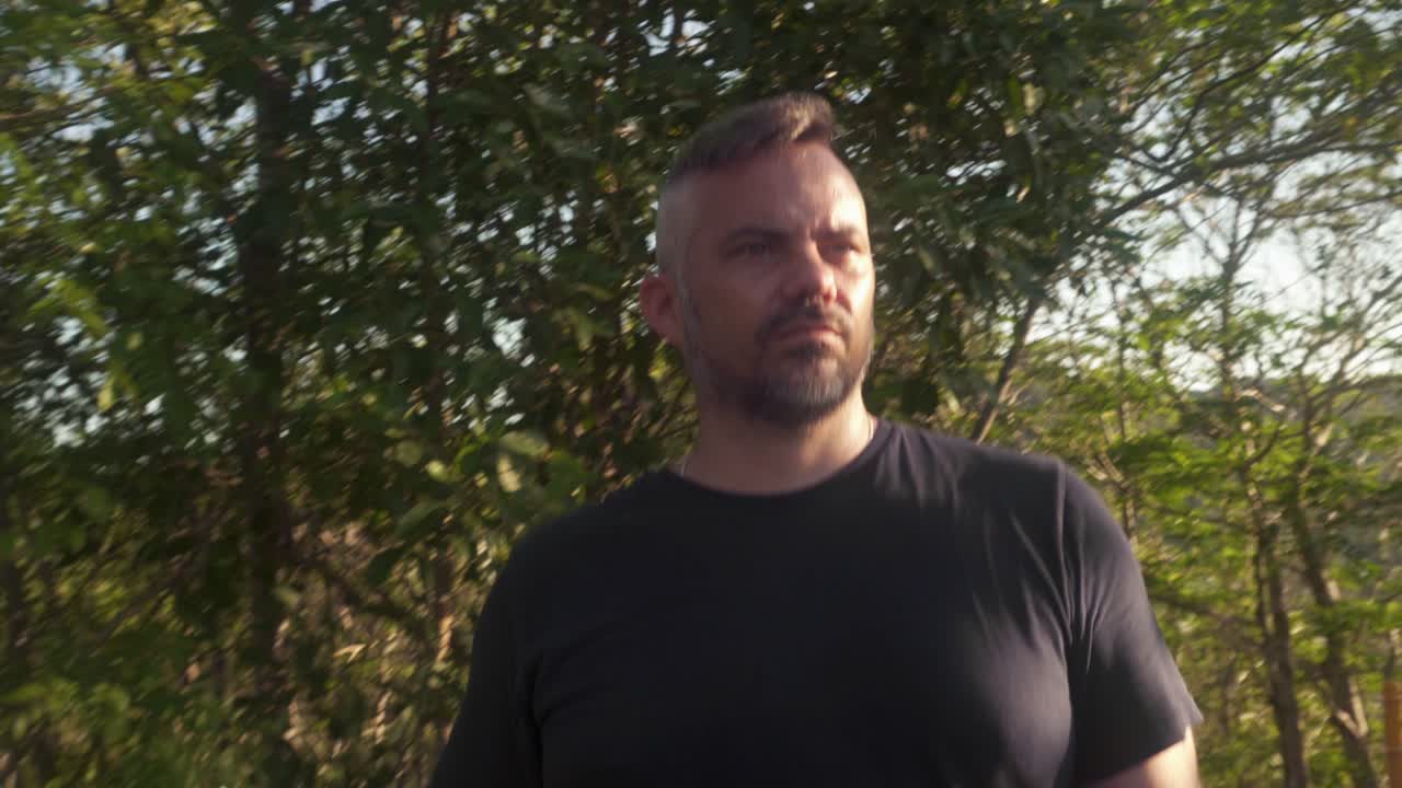 man walking towards camera along nature walk.