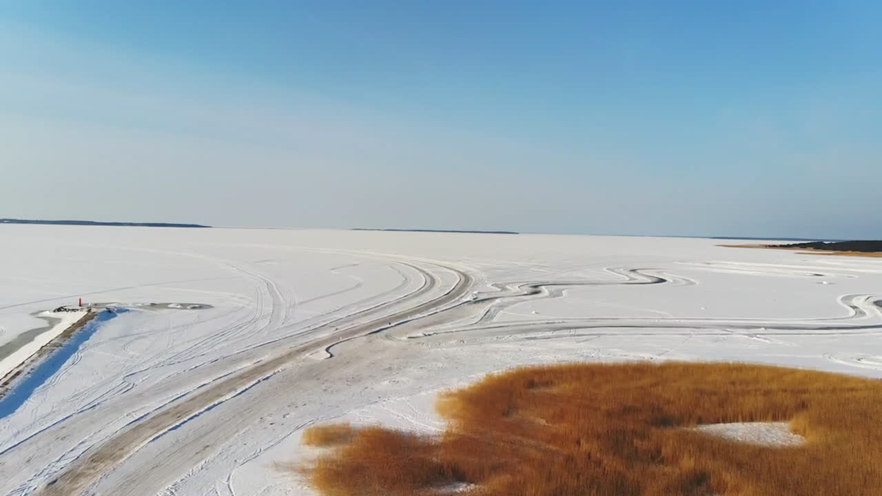 drone shot of Ice roads in Estonia during the winter snow with blue sky's