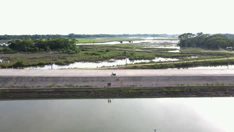 Aerial-View-Of-Drone-Operator-Standing-On-Flood-Embankment-At-Bholaganj-In-Sylhet