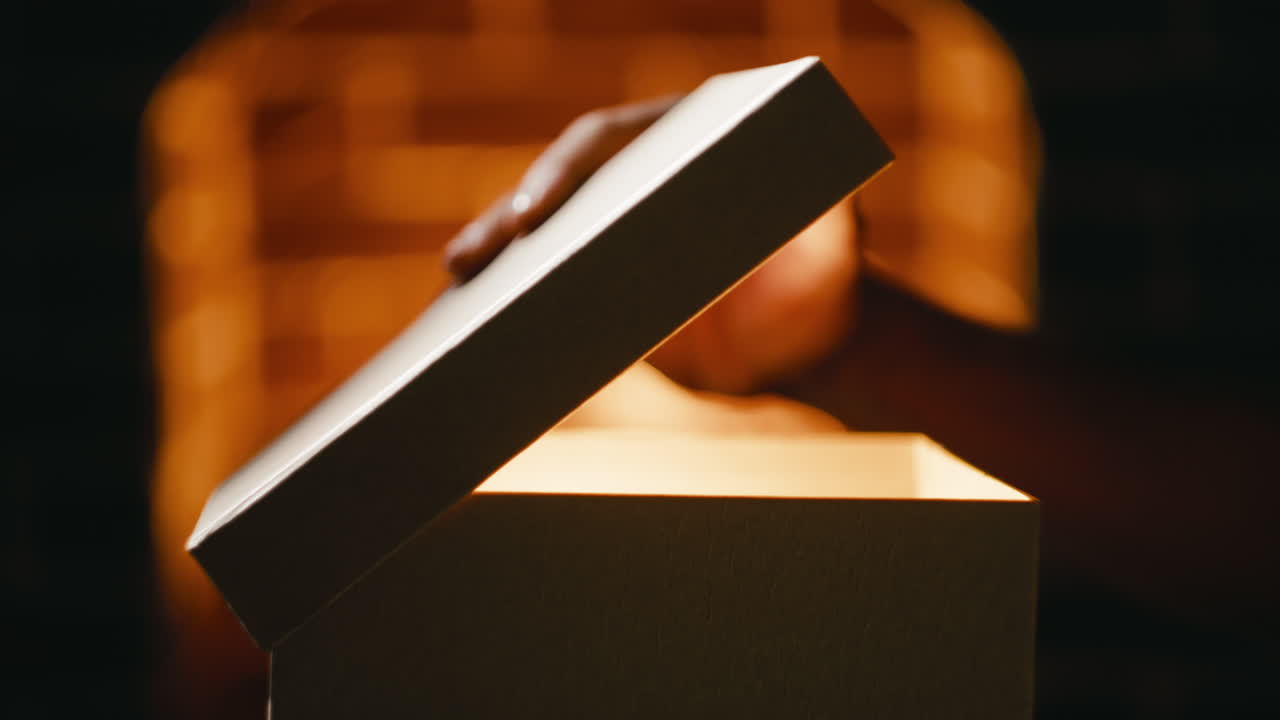 Hand opens mysterious package containing Christmas gifts