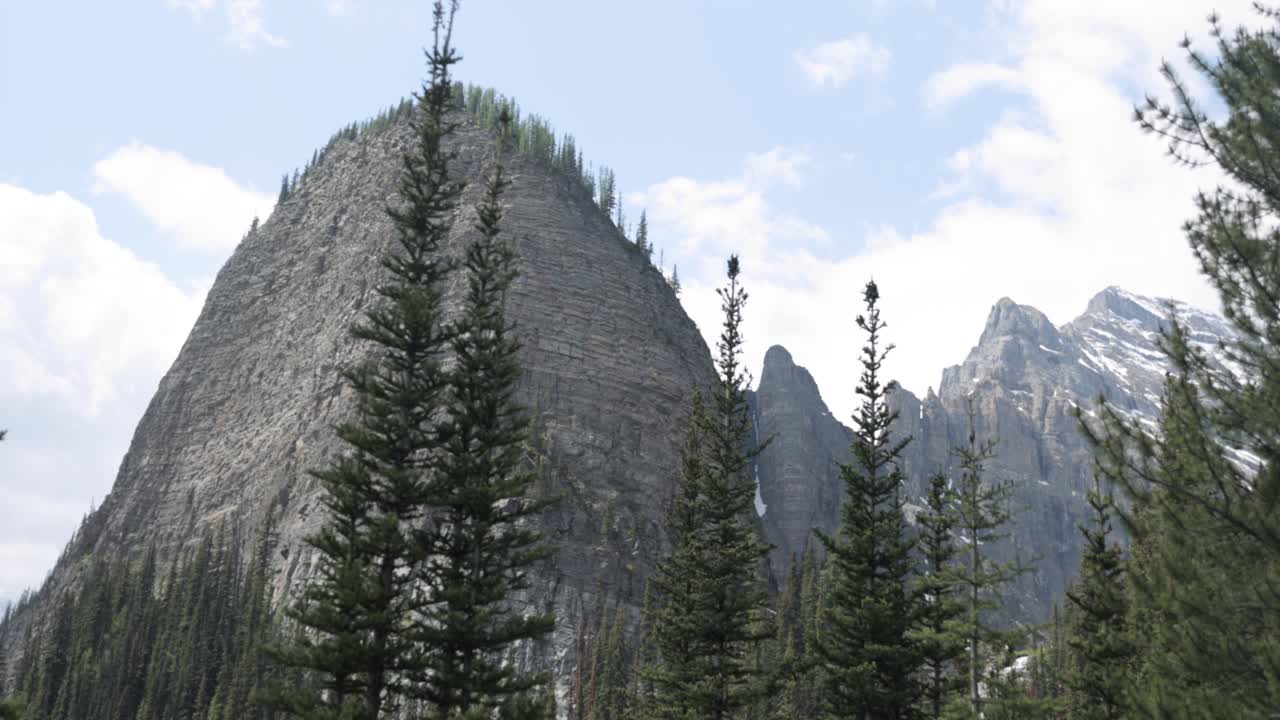 Beautiful view of a rocky mountain top from the hiking trail up to Lake Agnes Tea House on Mount St. Piran and Mount Whyte, within Banff National Park near Lake Louise Alberta.