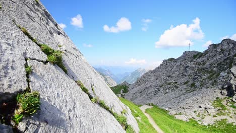 Wide-angle,-hand-hold-slide-out-of-white-rock-walls-showing-the-mountain-top-of-a-mountain-of-the-austrian-alps-under-a-blue-sky