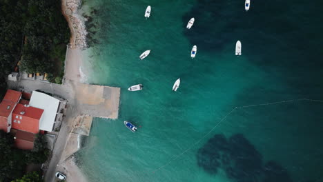 Drone-top-down-perspective-of-boats-anchored-in-neat-rows-off-slatina-beach-croatia