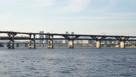 Subway-train-and-other-Vehicles-Passing-Through-Cheongdam-Bridge-Over-Han-River-In-Seoul,-South-Korea---static-shot-wide-angle-daytime