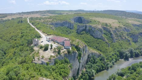 la casa de la cueva nacional con la entrada de la caverna de prohodna en el fondo en karlukovo, bulgaria