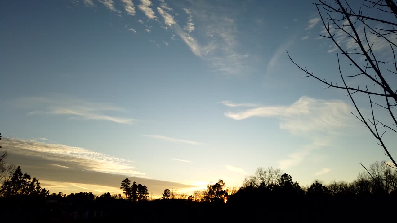 구름과 화학 트레일의 일몰 시간 경과