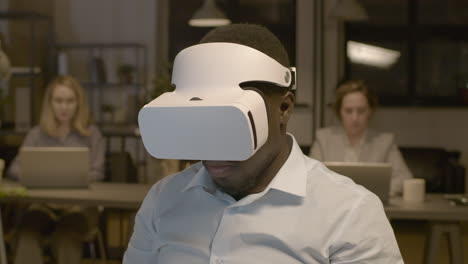 Nahaufnahme-Eines-Amerikanischen-Mannes,-Der-Am-Schreibtisch-Im-Büro-Sitzt-Und-Die-Hände-Bewegt-Und-Eine-Virtual-Reality-Brille-Trägt