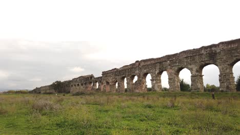 Detalle-De-Un-Acueducto-De-La-Antigua-Roma-En-Parco-Degli-Acquedotti-En-Las-Afueras-De-La-Capital-De-Italia,-Movimiento-Panorámico-Lento-Para-Revelar-La-Perspectiva