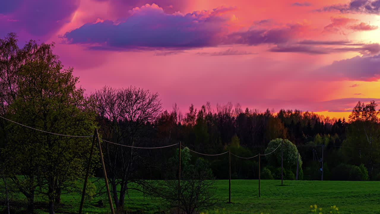 lapso de tiempo de una puesta de sol ardiente con nubes en movimiento rápido sobre un paisaje de naturaleza verde