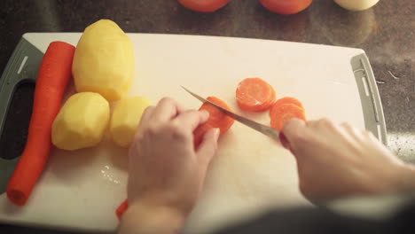 female hands cutting carrots in the kitchen in slow motion