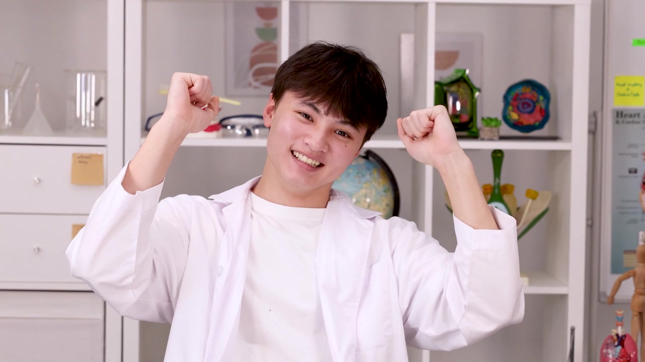 นักวิทยาศาสตร์หนุ่มสาวผู้มีความสุขกำลังฉลองความสำเร็จในห้องปฏิบัติการ