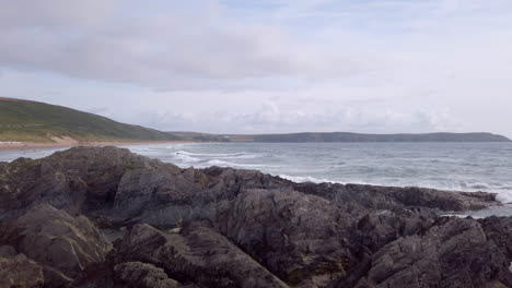 Panning-In-from-the-Atlantic-Ocean-to-Reveal-a-Rocky-Shoreline---Sandy-Beach