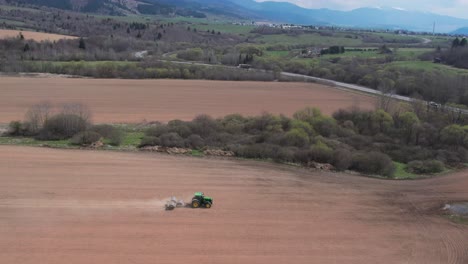vista aérea alta del campo de aplanamiento del tractor verde con rodillos pesados, paso elevado
