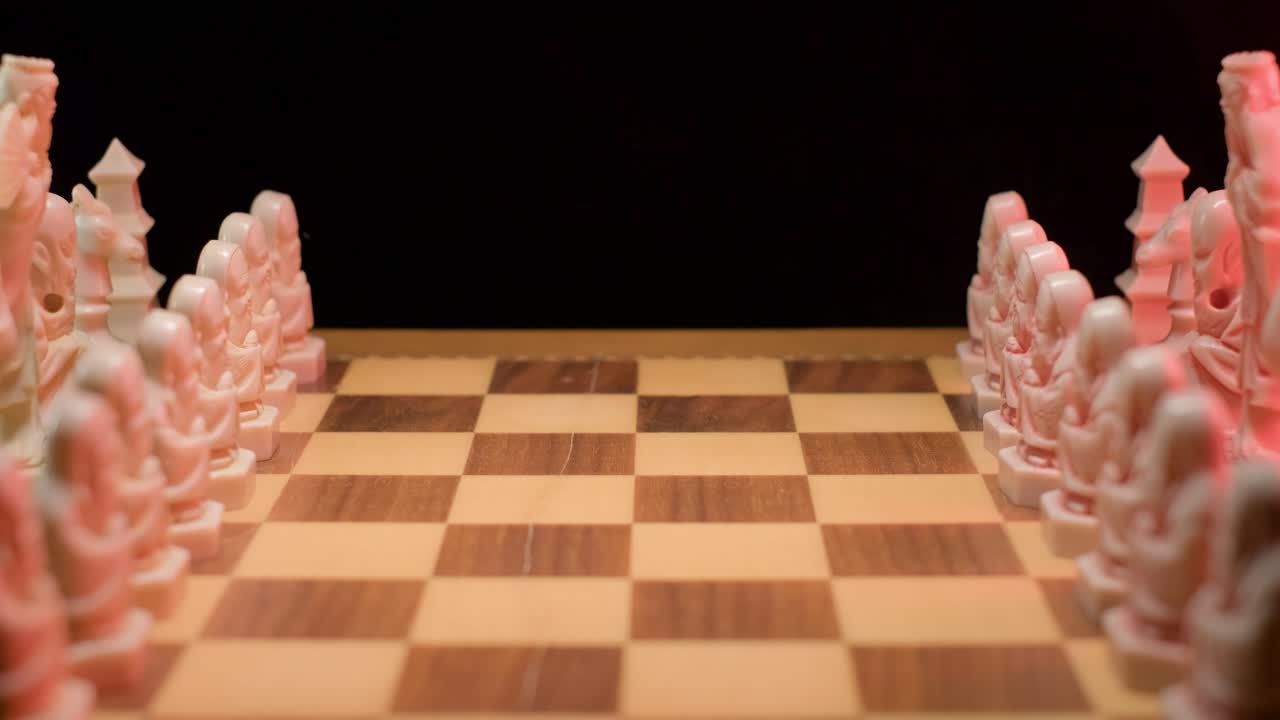 A close up shot dollying in towards the centre of a chessboard, all the pieces in place and ready for the first move to begin play