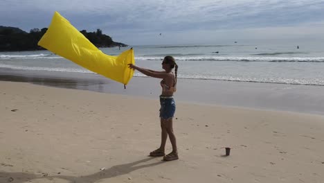 mujer inflando una silla de playa amarilla en la playa