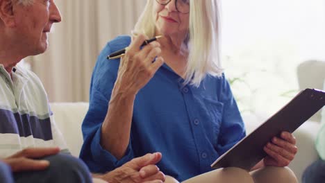 senior caucasian female therapist making notes, talking with senior man, slow motion
