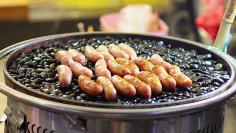 salchichas girando piedras calientes en una parrilla